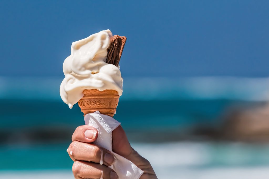 A hand holding melting ice cream